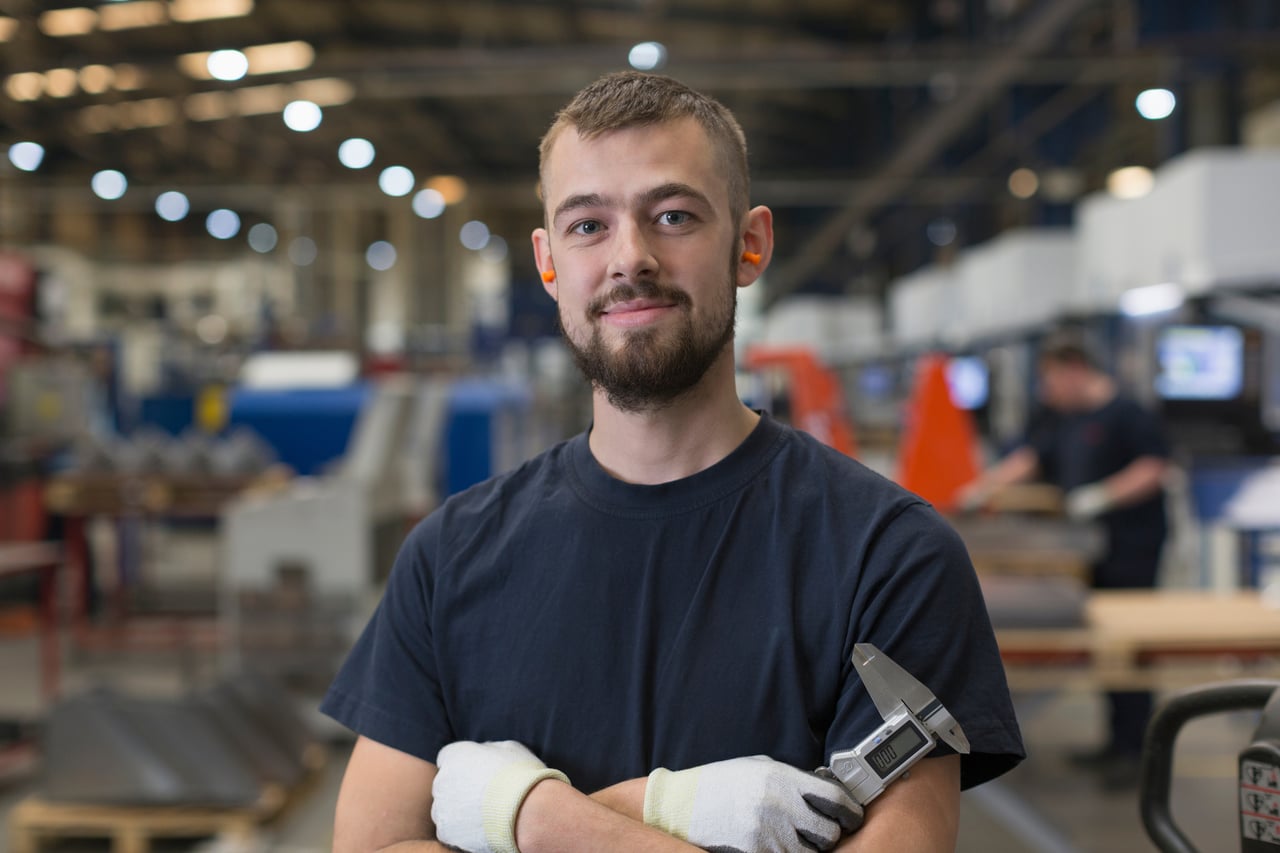 Person posing in industrial workplace.