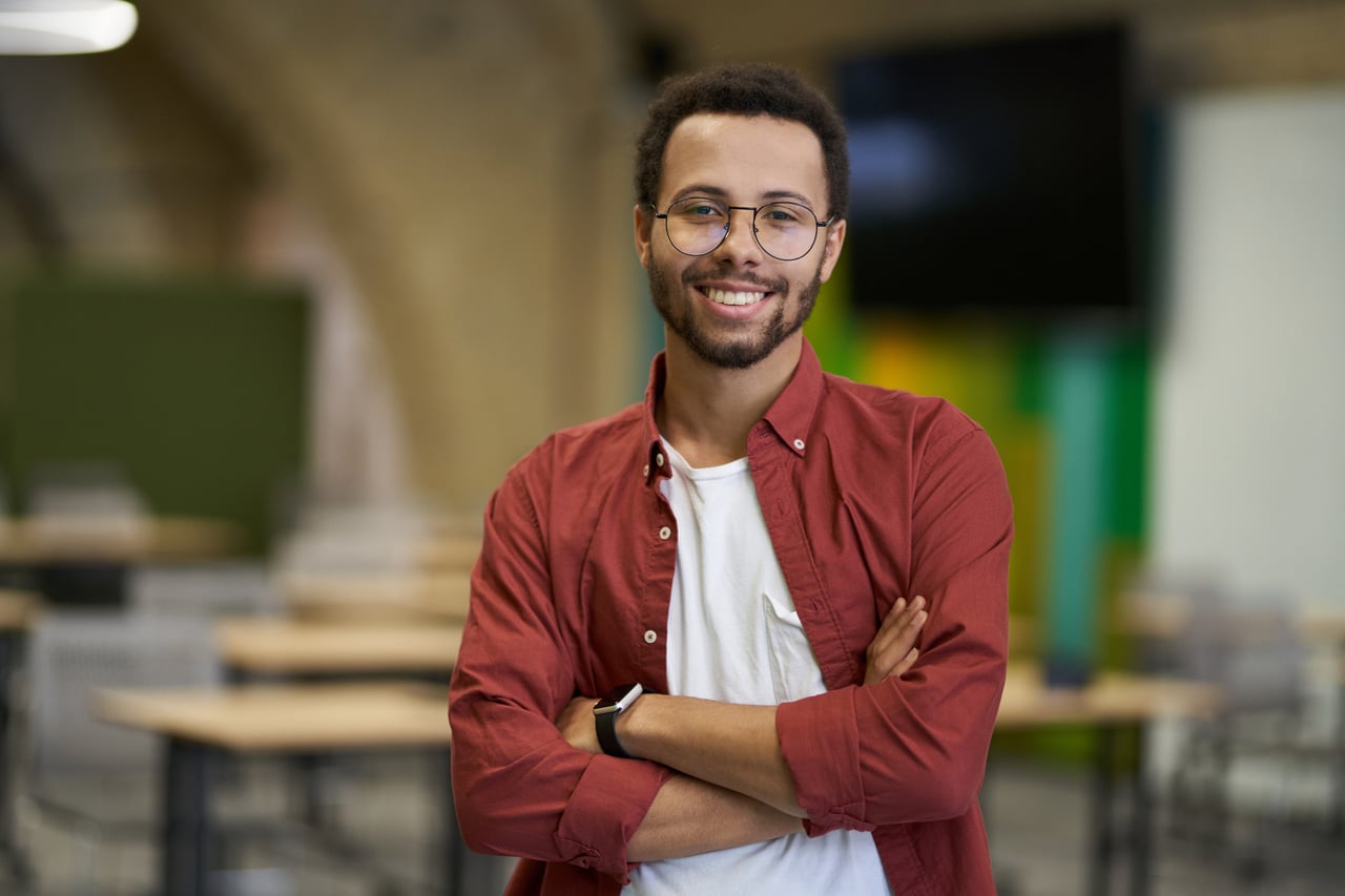 Person standing with arms crossed in classroom.